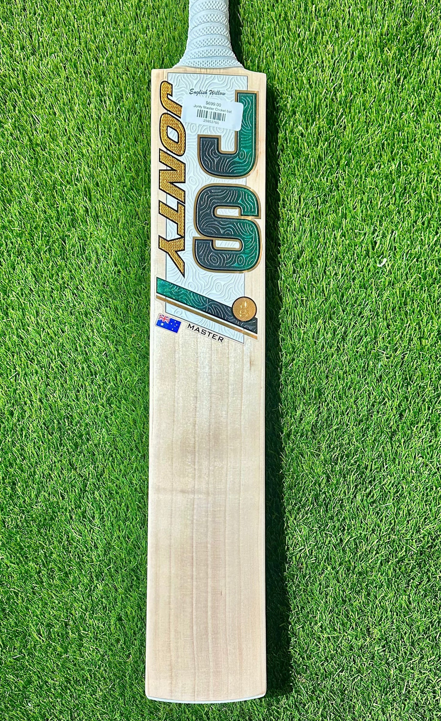 Jonty Master Grade-1 English Willow cricket bat with green and gold branding on a grass background
