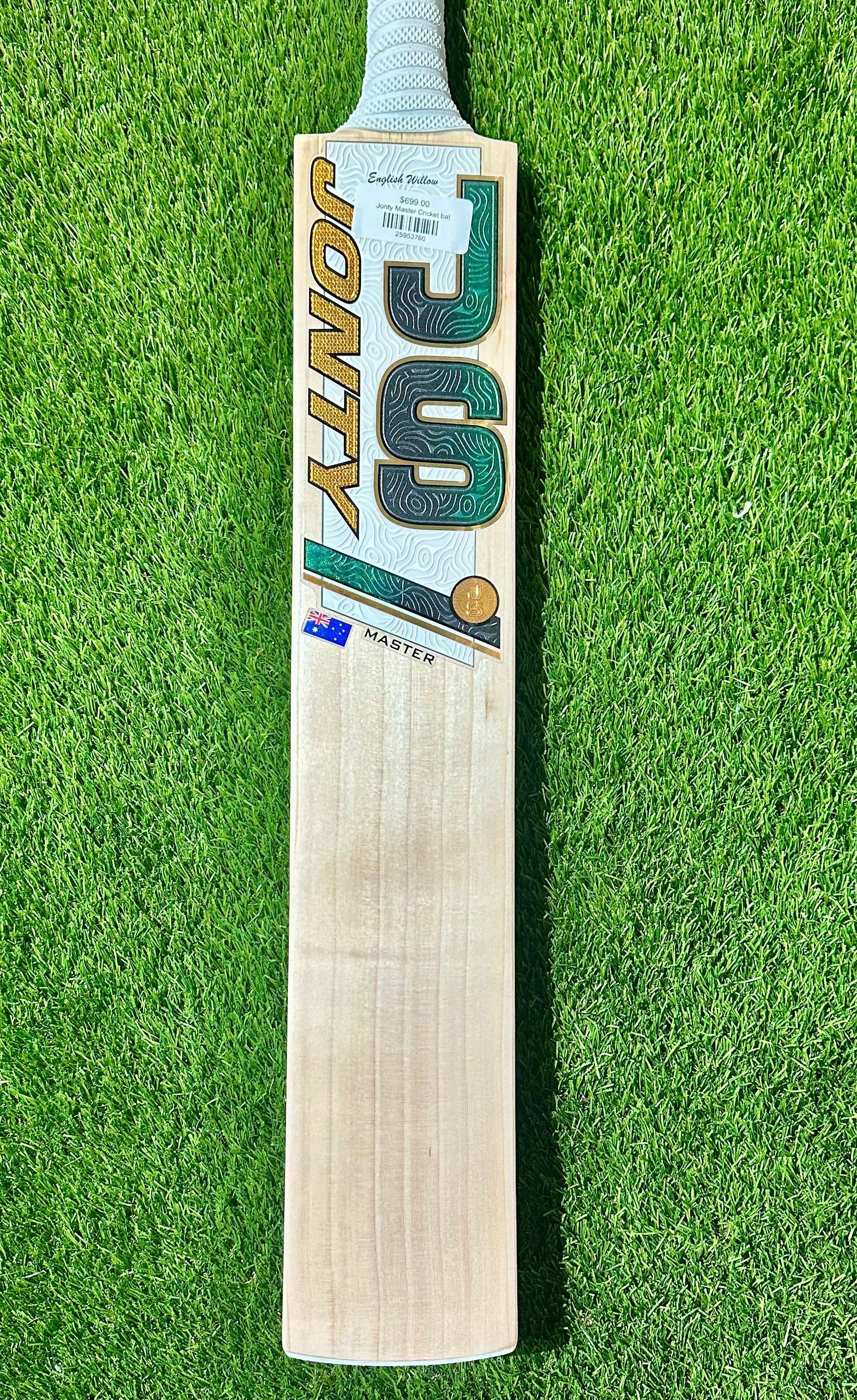 Jonty Master Grade-1 English Willow cricket bat with green and gold branding on a grass background