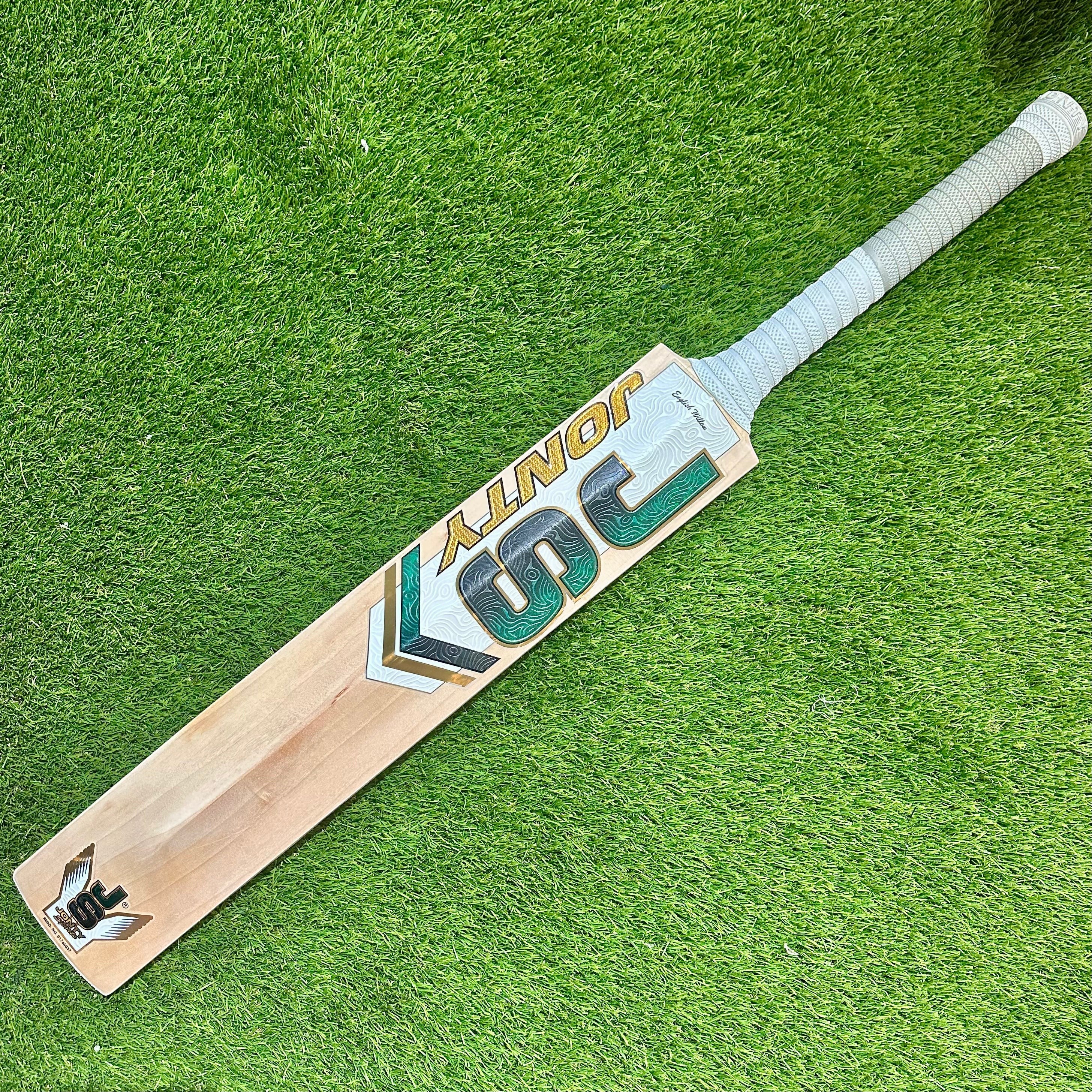 Jonty Masters Grade-1 English Willow cricket bat with white handle grip on green grass background
