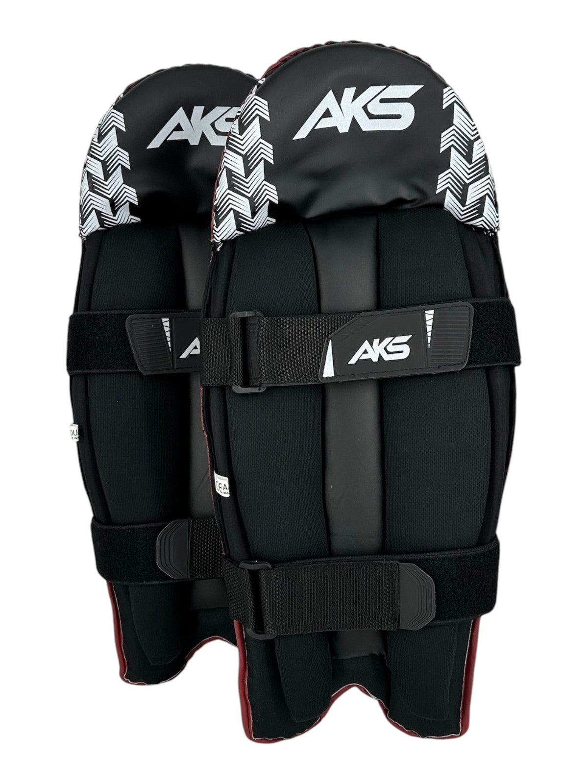 AKS CRICKET red and black wicket keeping pads with white chevron pattern, moulded knee roll, and adjustable straps.