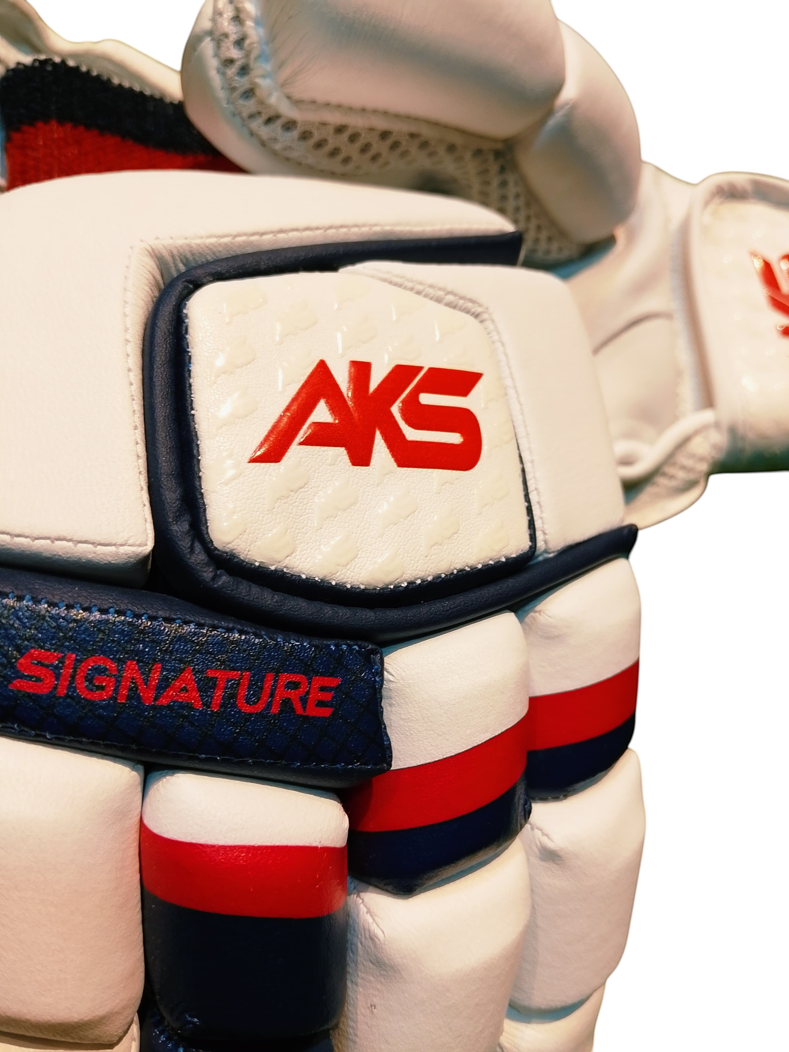 AKS CRICKET Signature batting gloves in white with navy and red accents, featuring high-density foam finger protection.